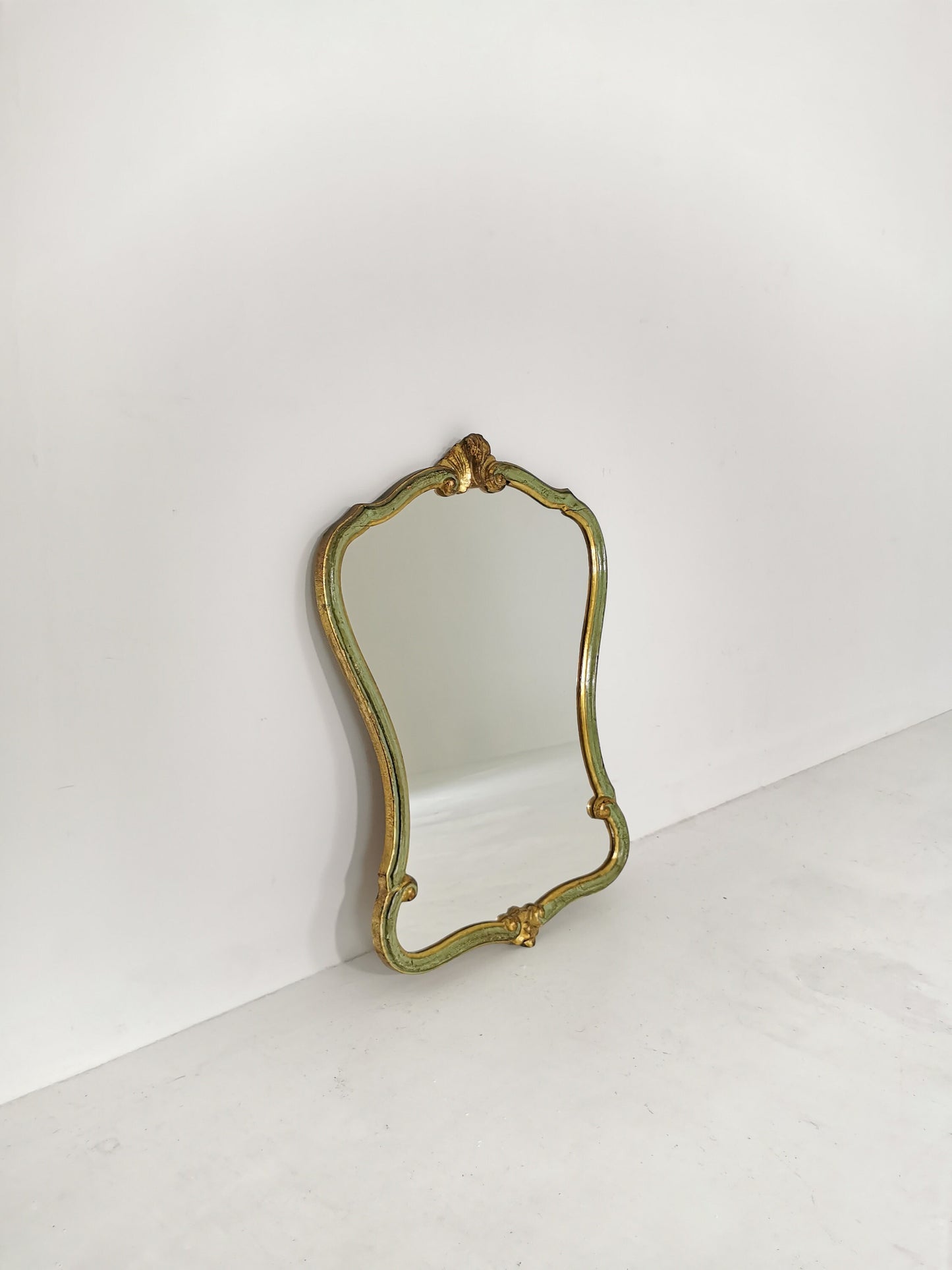 Classic style mirror in gold leaf with shaped frame Italy 1980s.