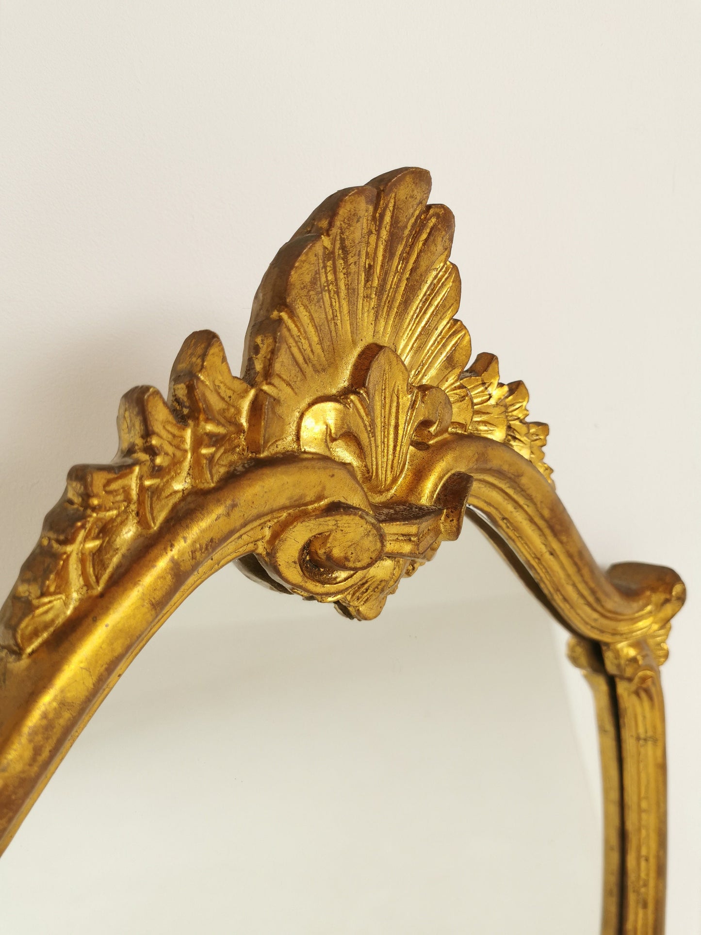 Classic style mirror in gold leaf with shaped frame Italy 1980s.