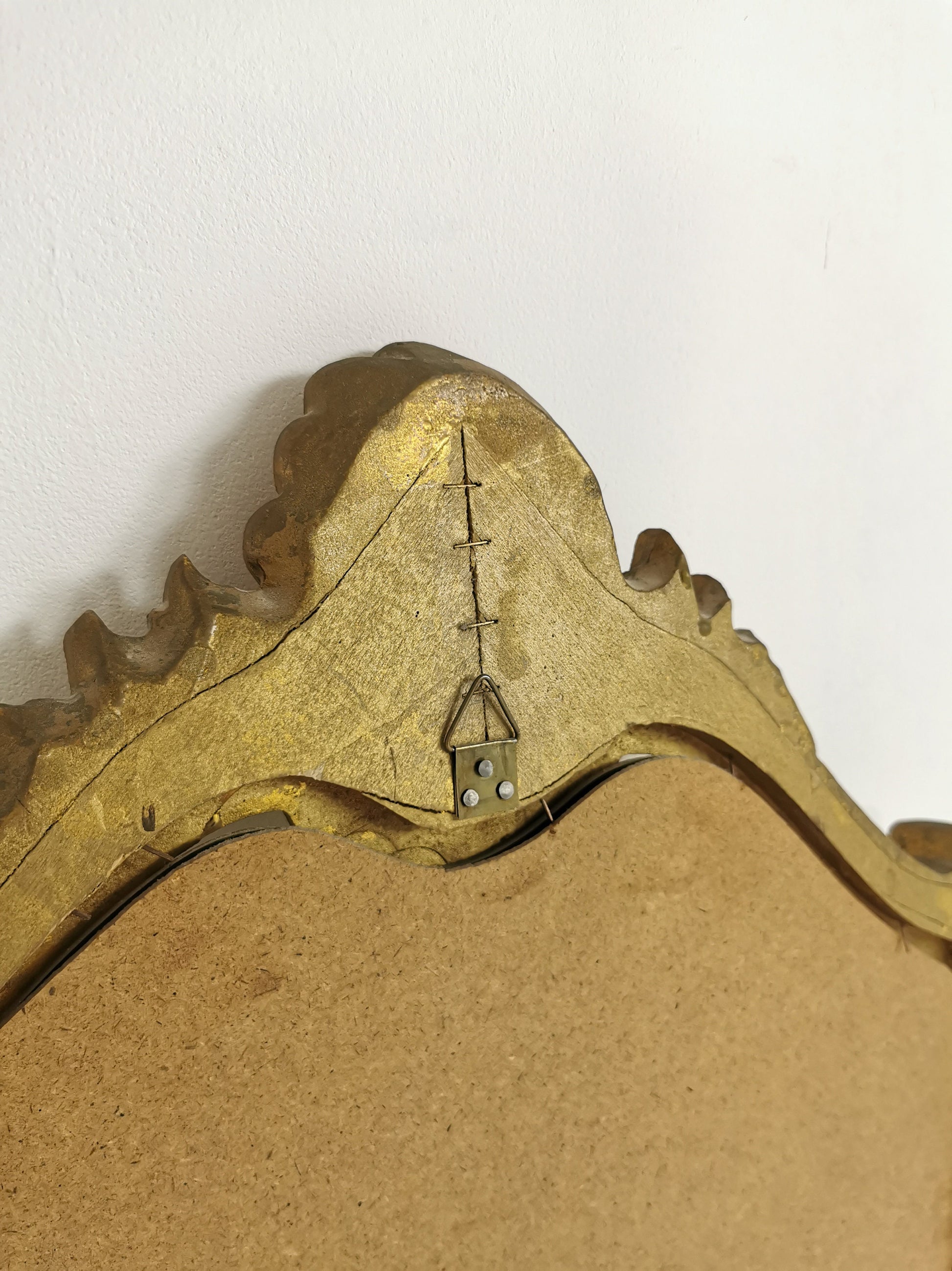 Classic style mirror in gold leaf with shaped frame Italy 1980s.