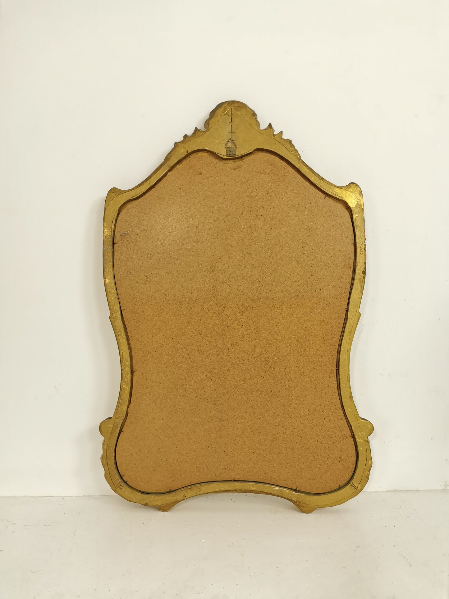 Classic style mirror in gold leaf with shaped frame Italy 1980s.