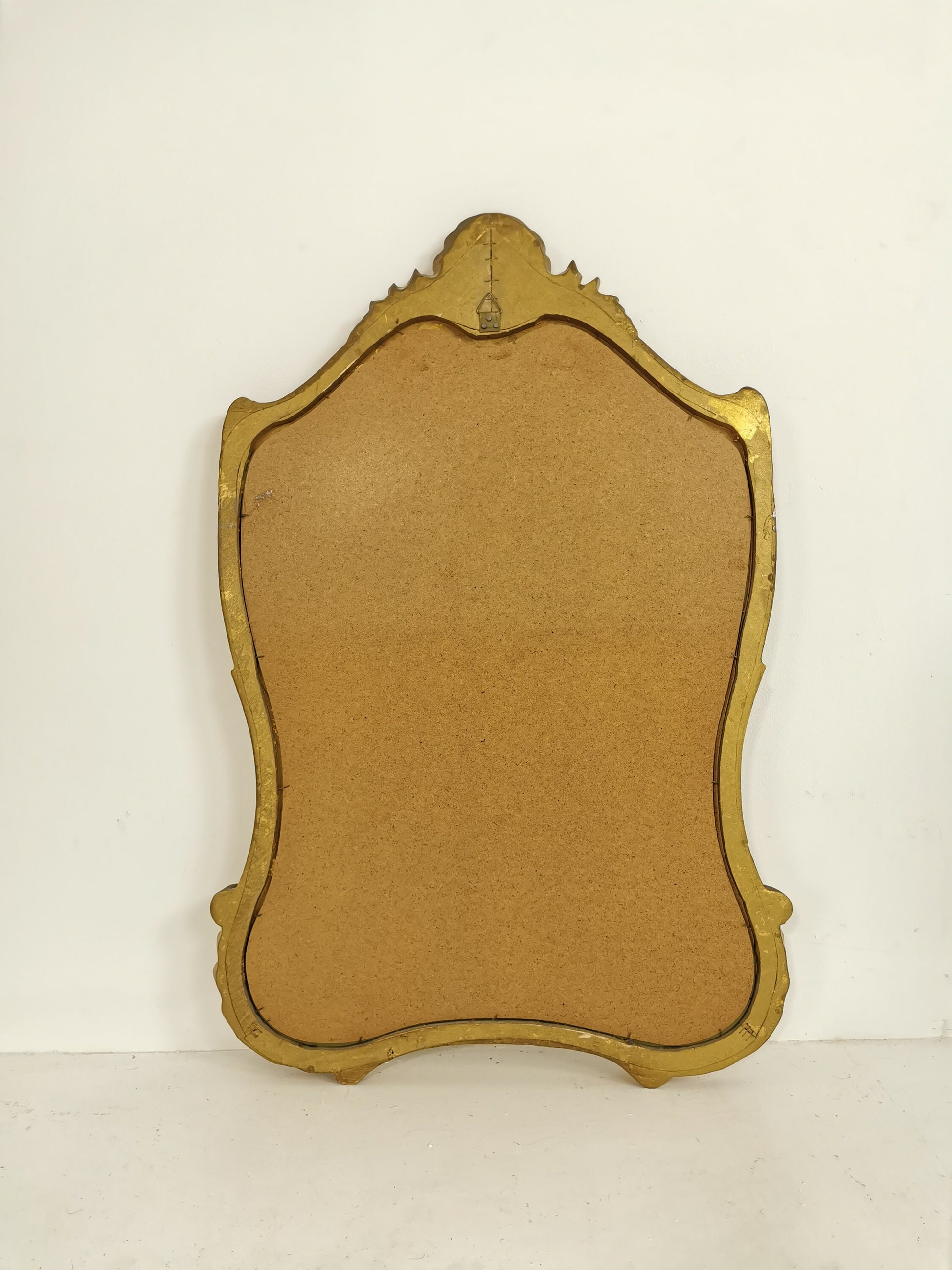 Classic style mirror in gold leaf with shaped frame Italy 1980s.