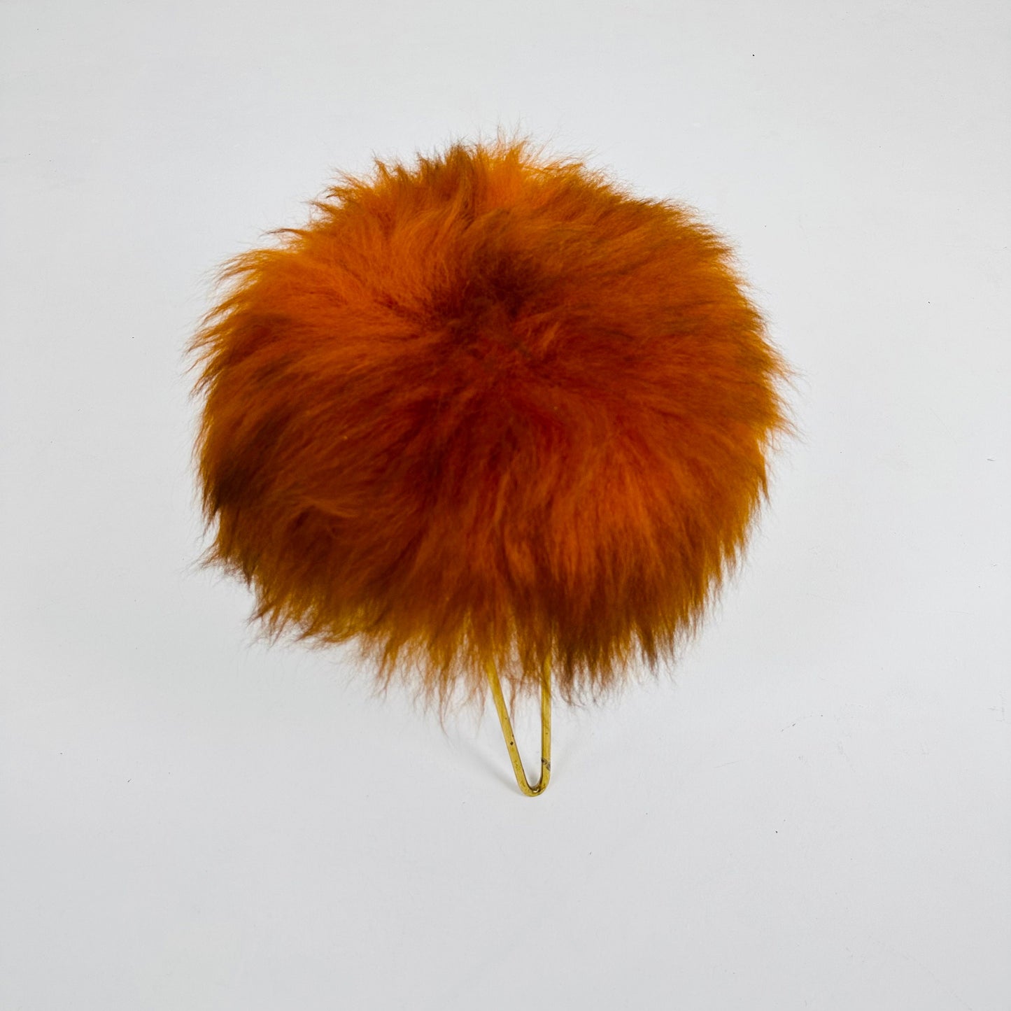 Beautiful midcentury orange flokati stool with goat hair cover and tripod hairpin feet. 1950s