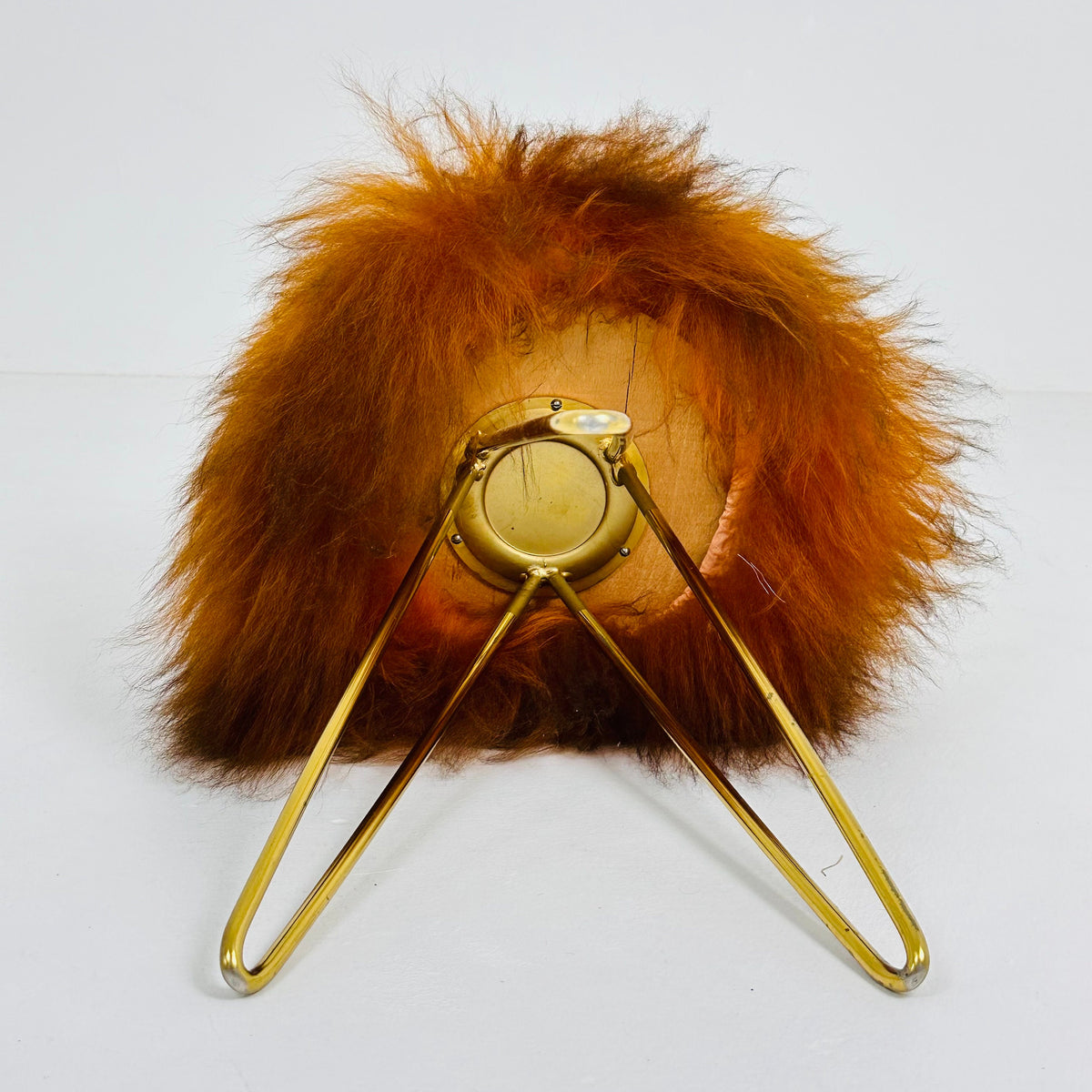 Beautiful midcentury orange flokati stool with goat hair cover and tripod hairpin feet. 1950s
