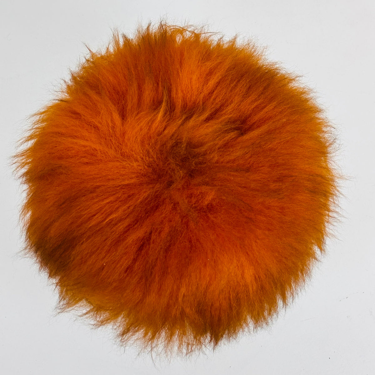 Beautiful midcentury orange flokati stool with goat hair cover and tripod hairpin feet. 1950s