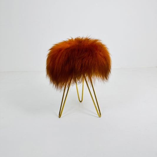 Beautiful midcentury orange flokati stool with goat hair cover and tripod hairpin feet. 1950s