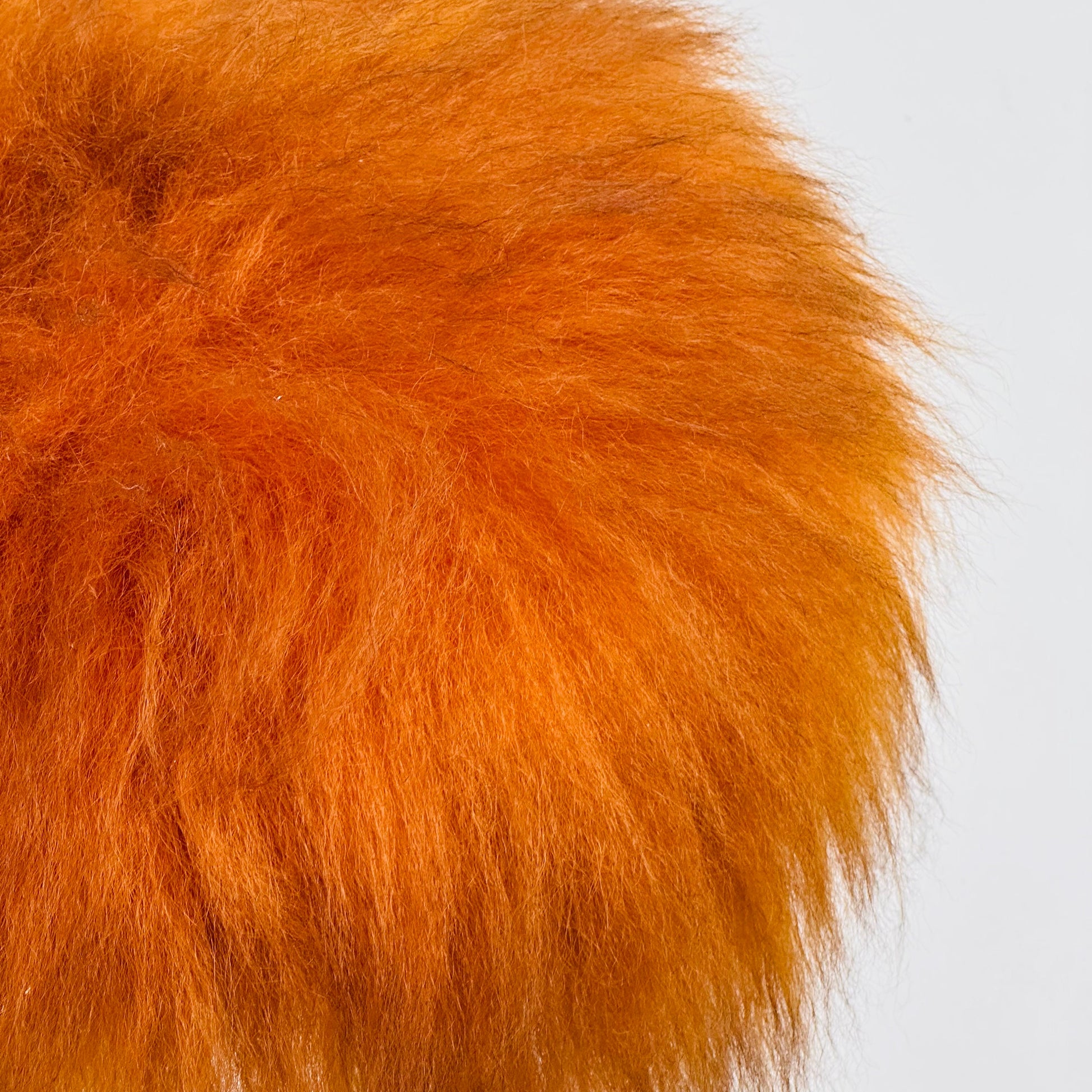 Beautiful midcentury orange flokati stool with goat hair cover and tripod hairpin feet. 1950s