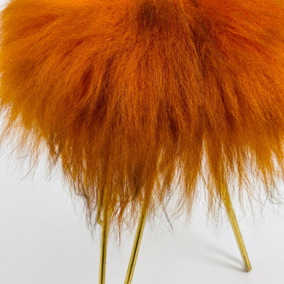 Beautiful midcentury orange flokati stool with goat hair cover and tripod hairpin feet. 1950s